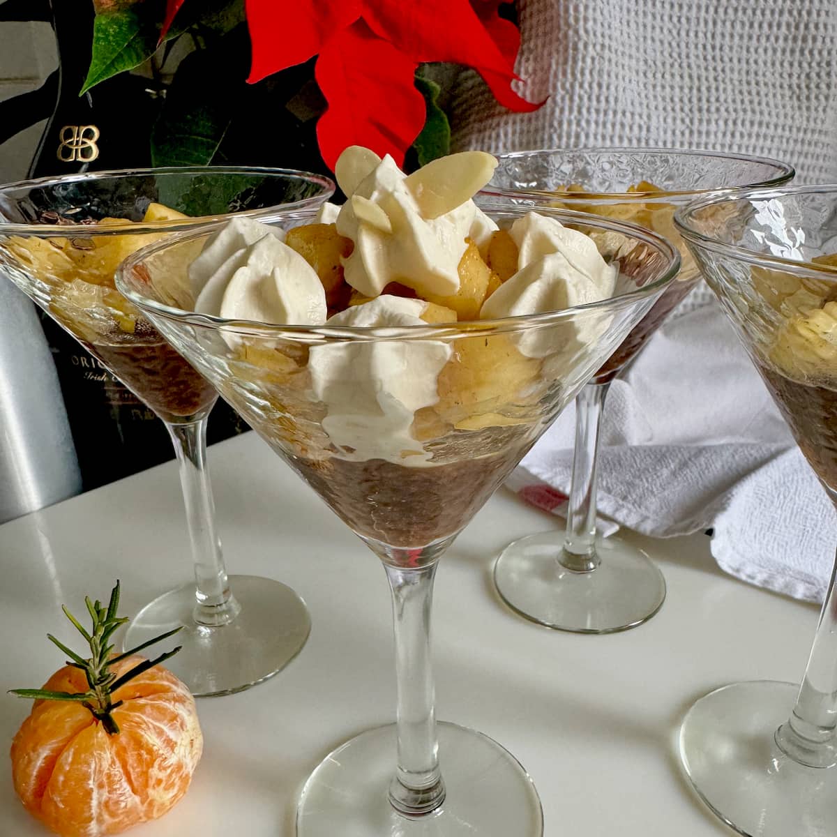 glass with a layered gingerbread trifle with caramelised apples, jelly, caramel and topped with boozy whipped cream