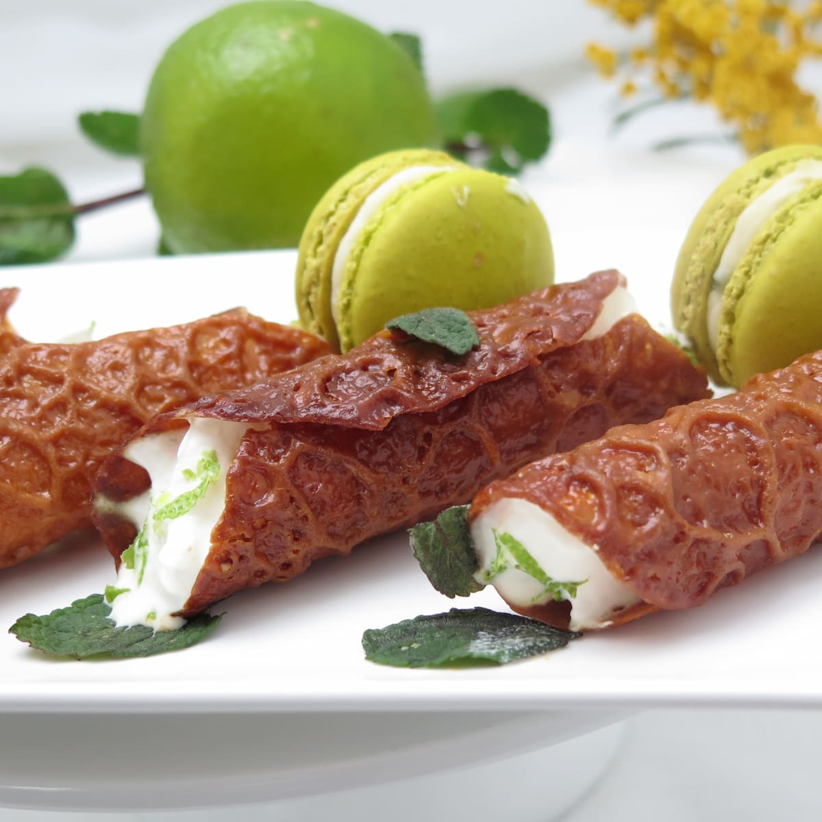 Tubes of brandy snaps filled with whipped cream, mint, lime and rum