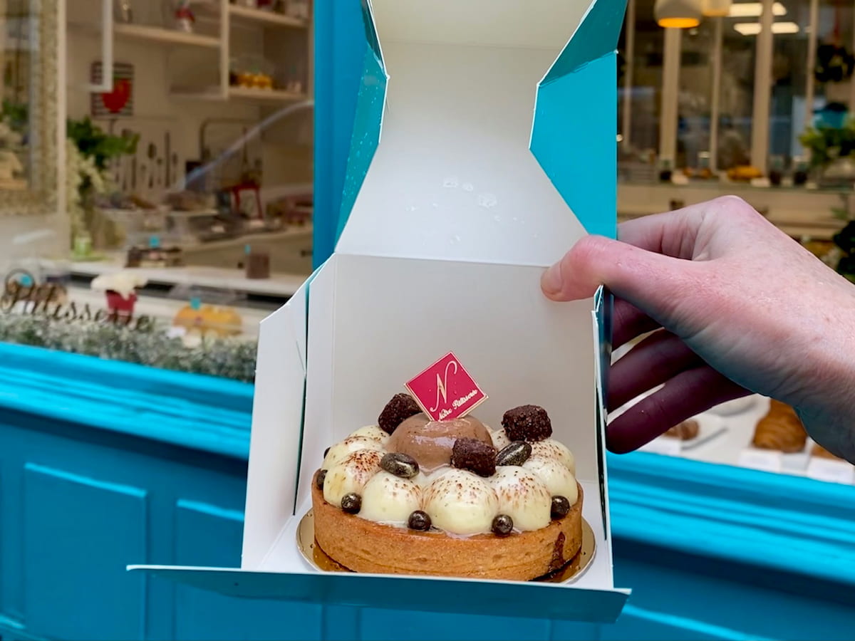 holding a turquoise pastry box with a cake like a flower