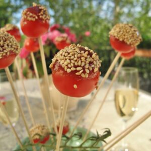 candied cherry tomatoes on sticks, topped with sesame seeds