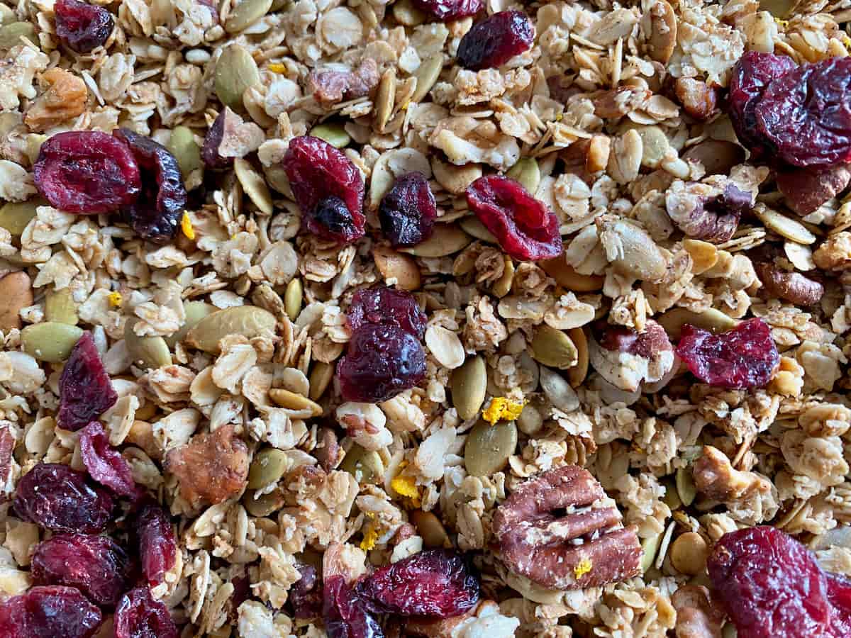 crispy granola topped with dried cranberries, orange zest toasted nuts and oats
