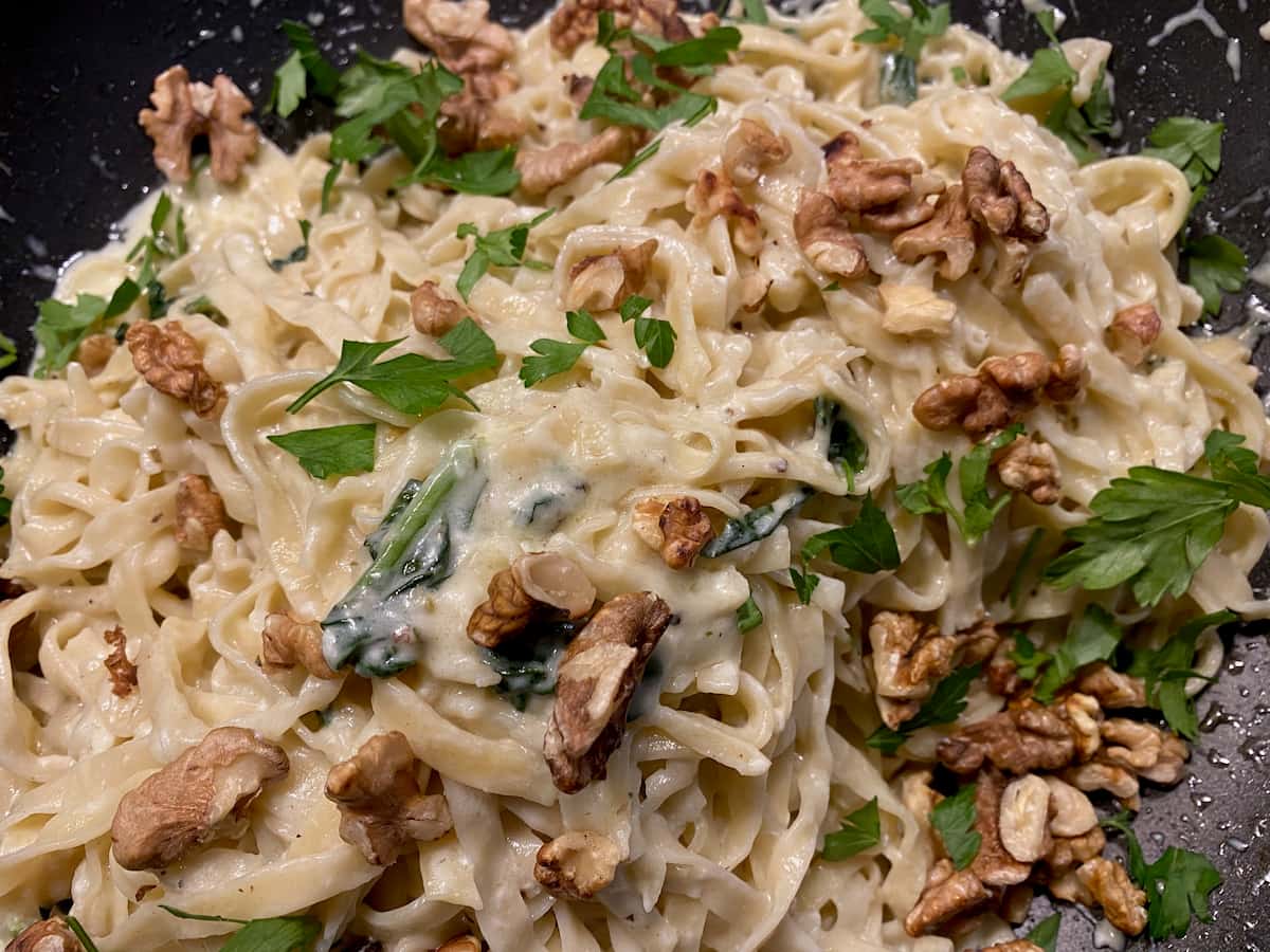 fresh pasta tossed in melted goat cheese and cream topped with fresh parsley and walnuts