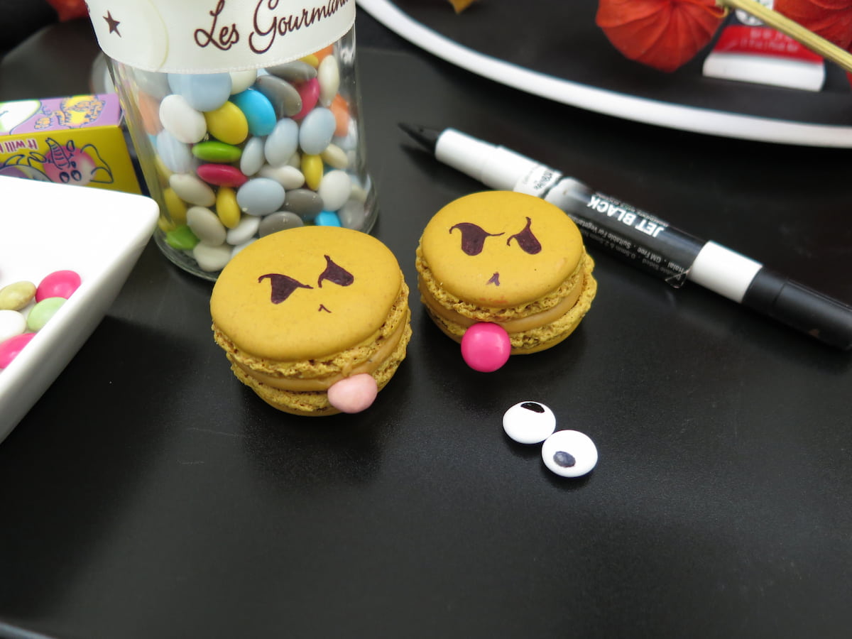 2 green macarons with eyes and smarties as tongues for a halloween idea