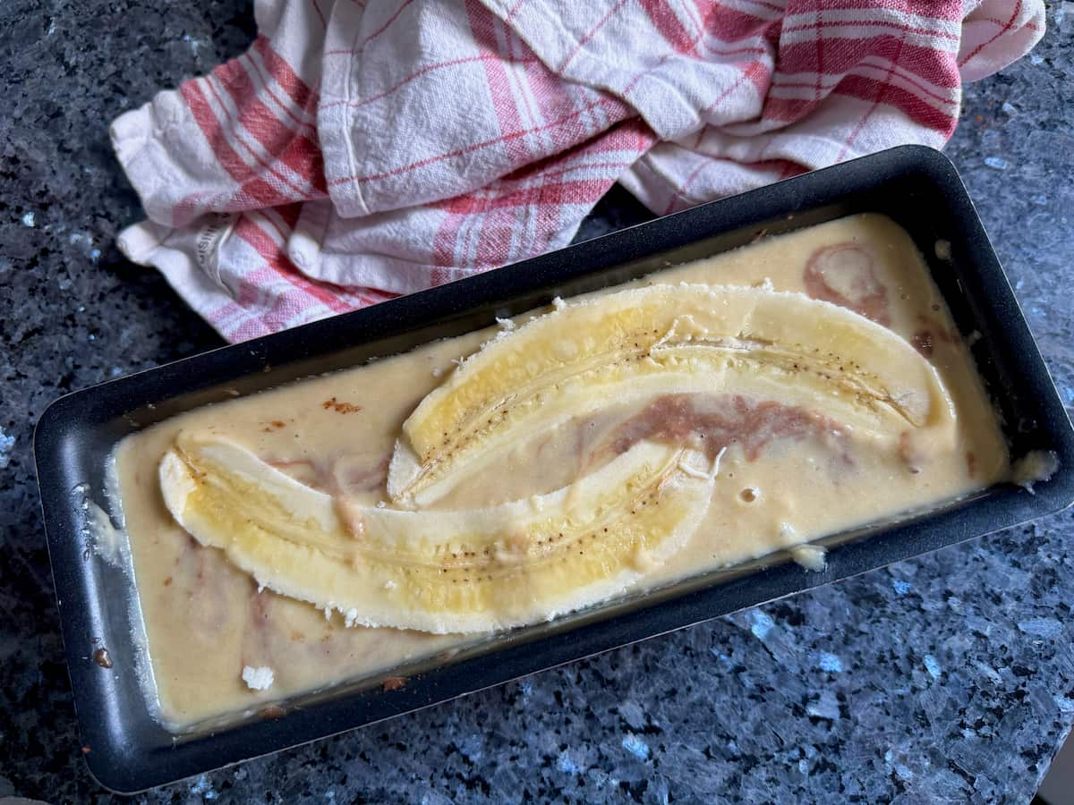 hidden batters under sliced banana in a cake tin