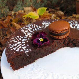 fudgy chocolate cake sliced open with chocolate macaron on top