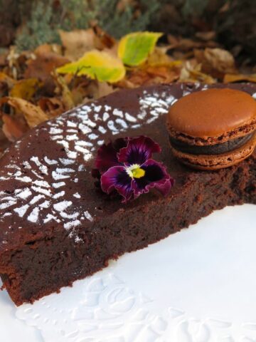 fudgy chocolate cake sliced open with chocolate macaron on top