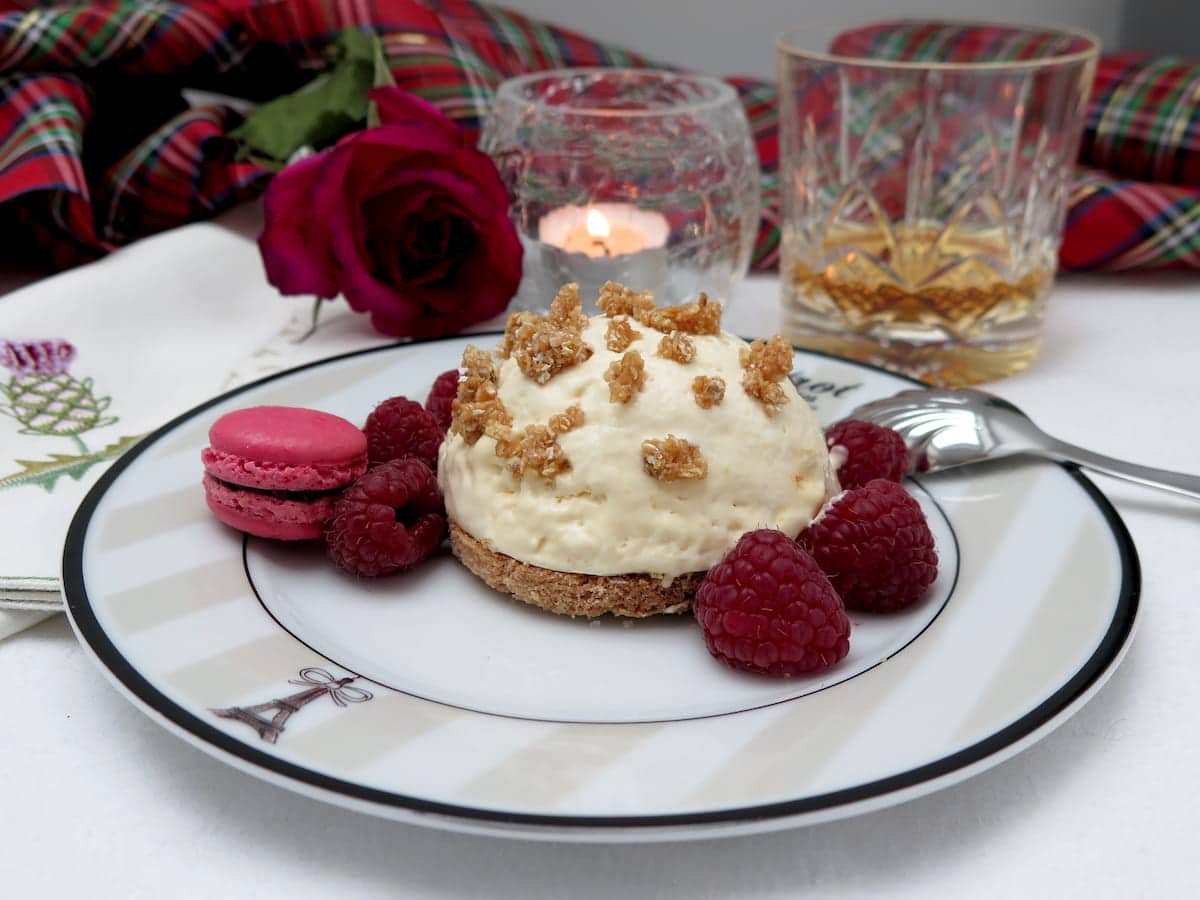 dome of honey ice cream on a disk of shortbread topped with praline and raspberries