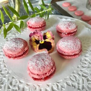 pink macarons on white plate and pink pansy with lemon verbena plant