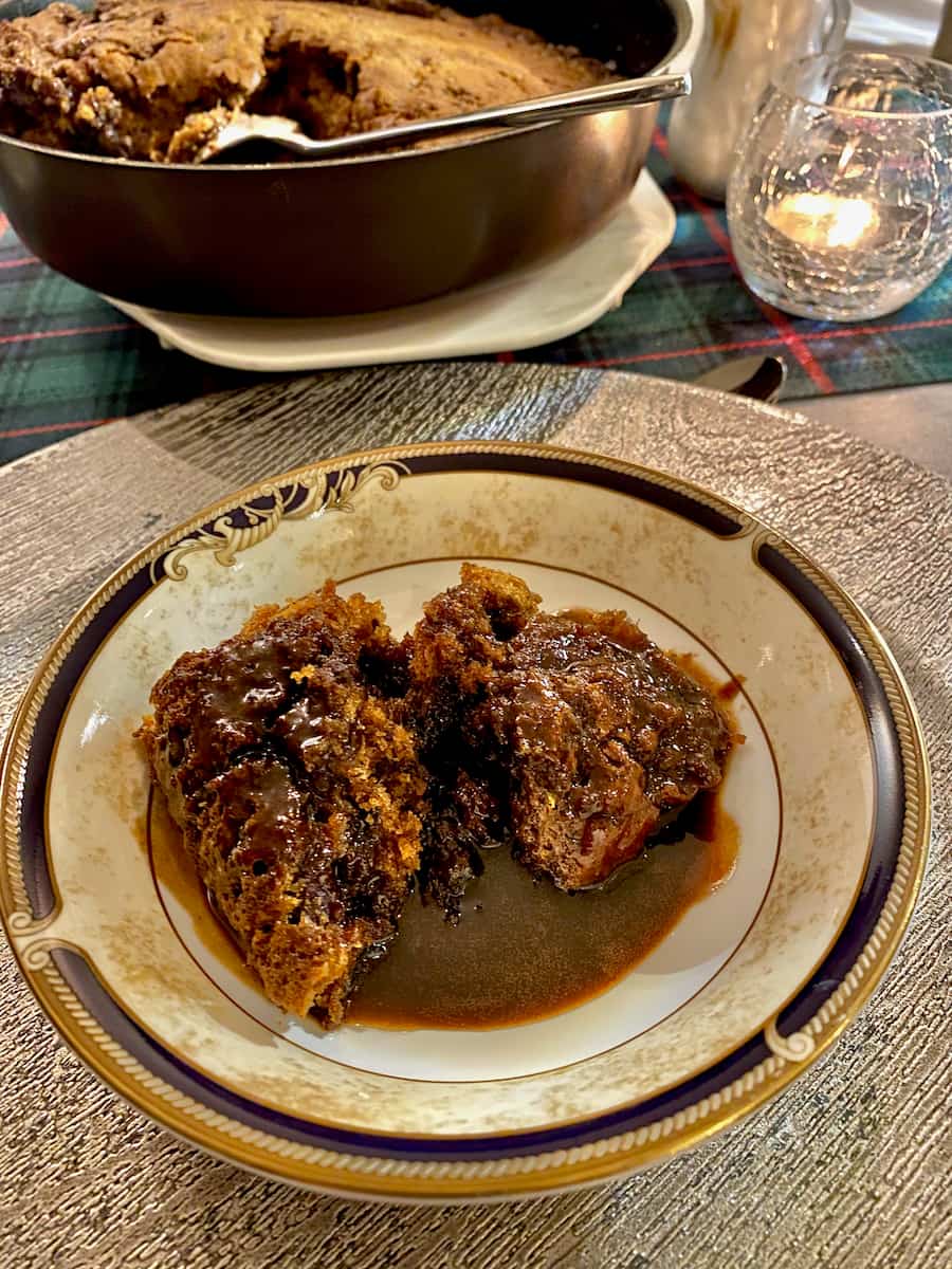 bowl of dark toffee pudding with a lush sauce