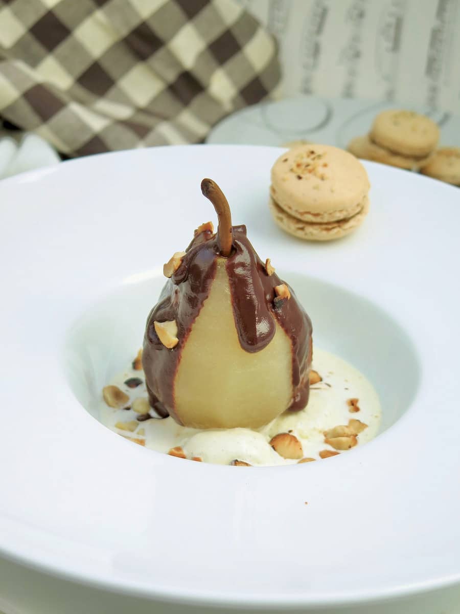 poached pear belle helene dessert topped with thick chocolate sauce