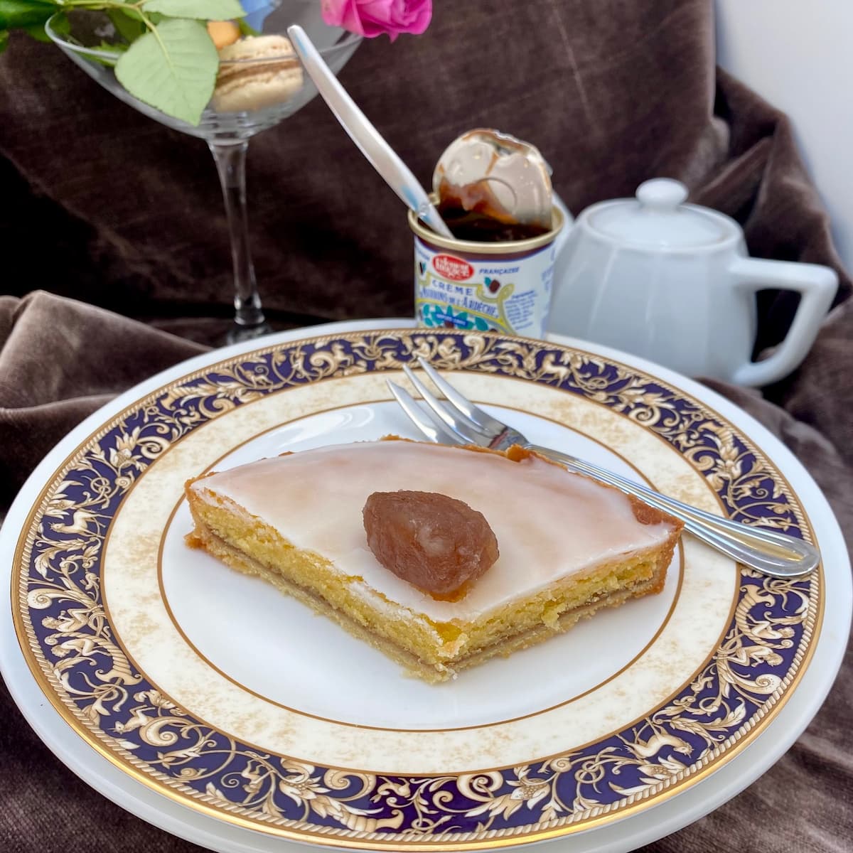 slice of almond chestnut tart with white glaze and topped with a candied chestnut