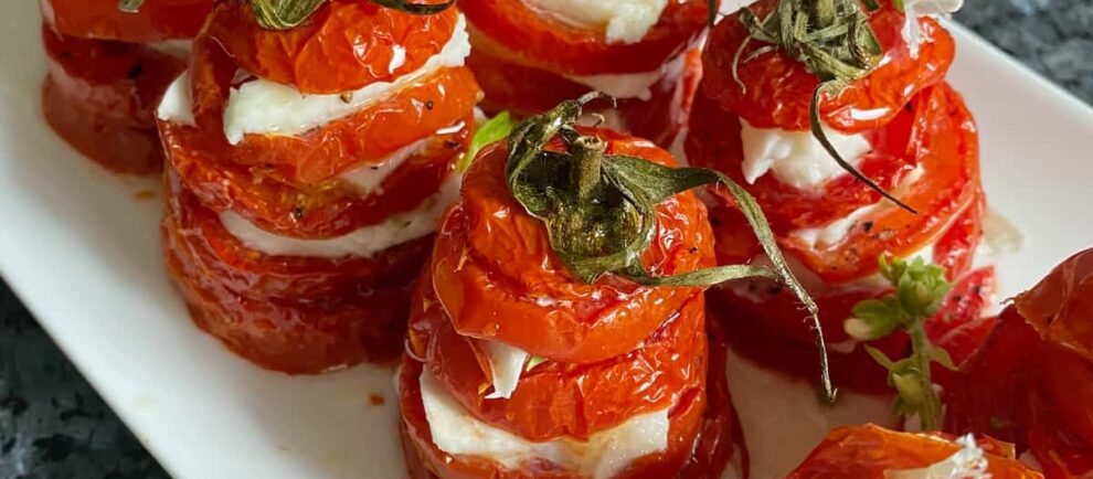 roasted sliced tomatoes with mozzarella stacked together