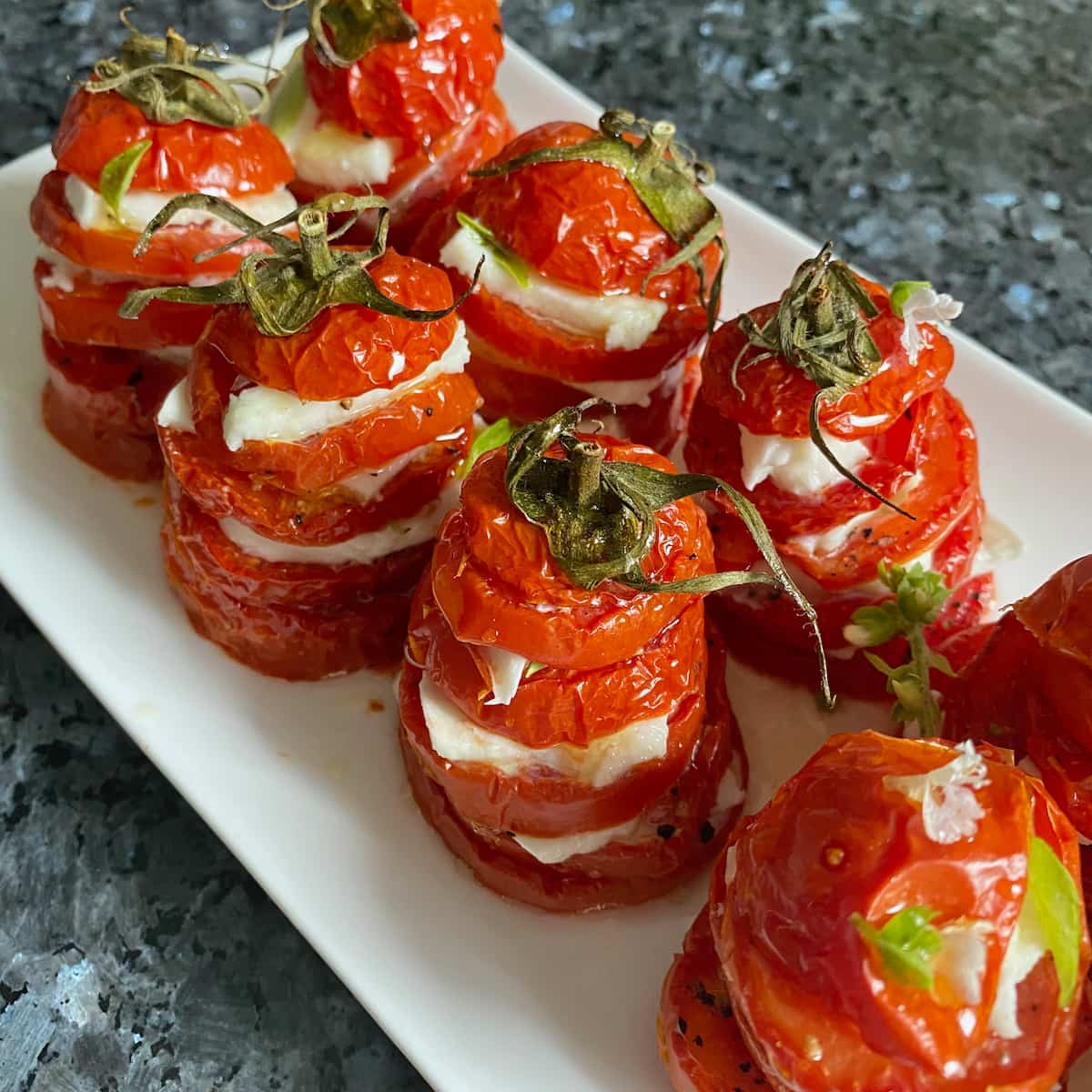 roasted sliced tomatoes with mozzarella stacked together