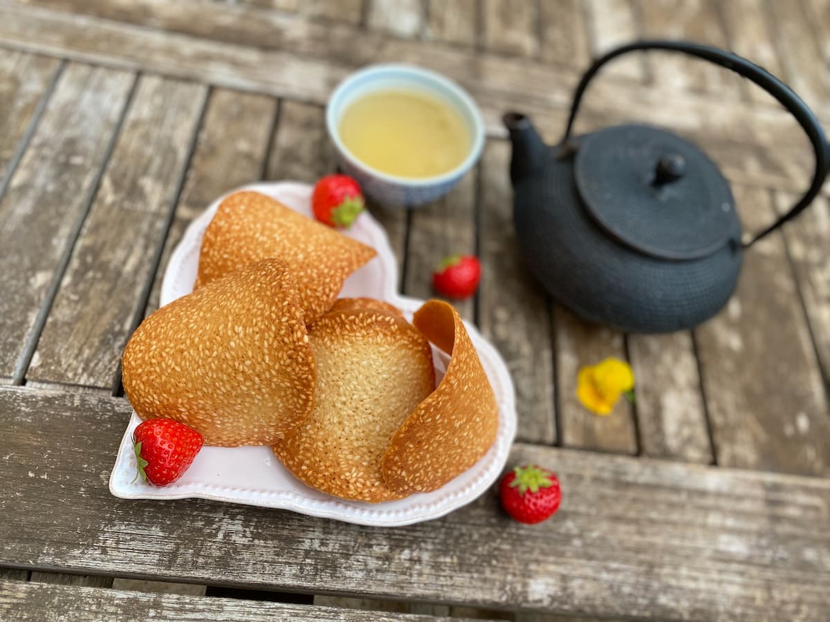 plate of curved golden tuile cookies with tea