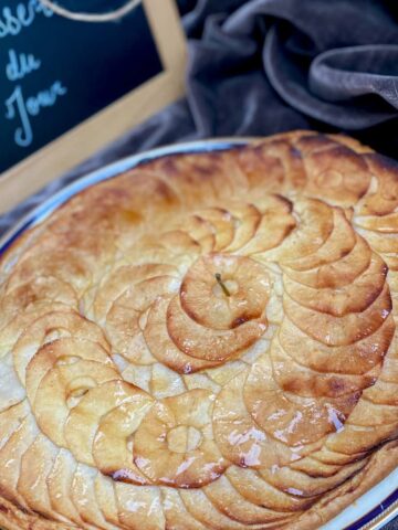 round thin tart topped with thinly sliced spiral of apples