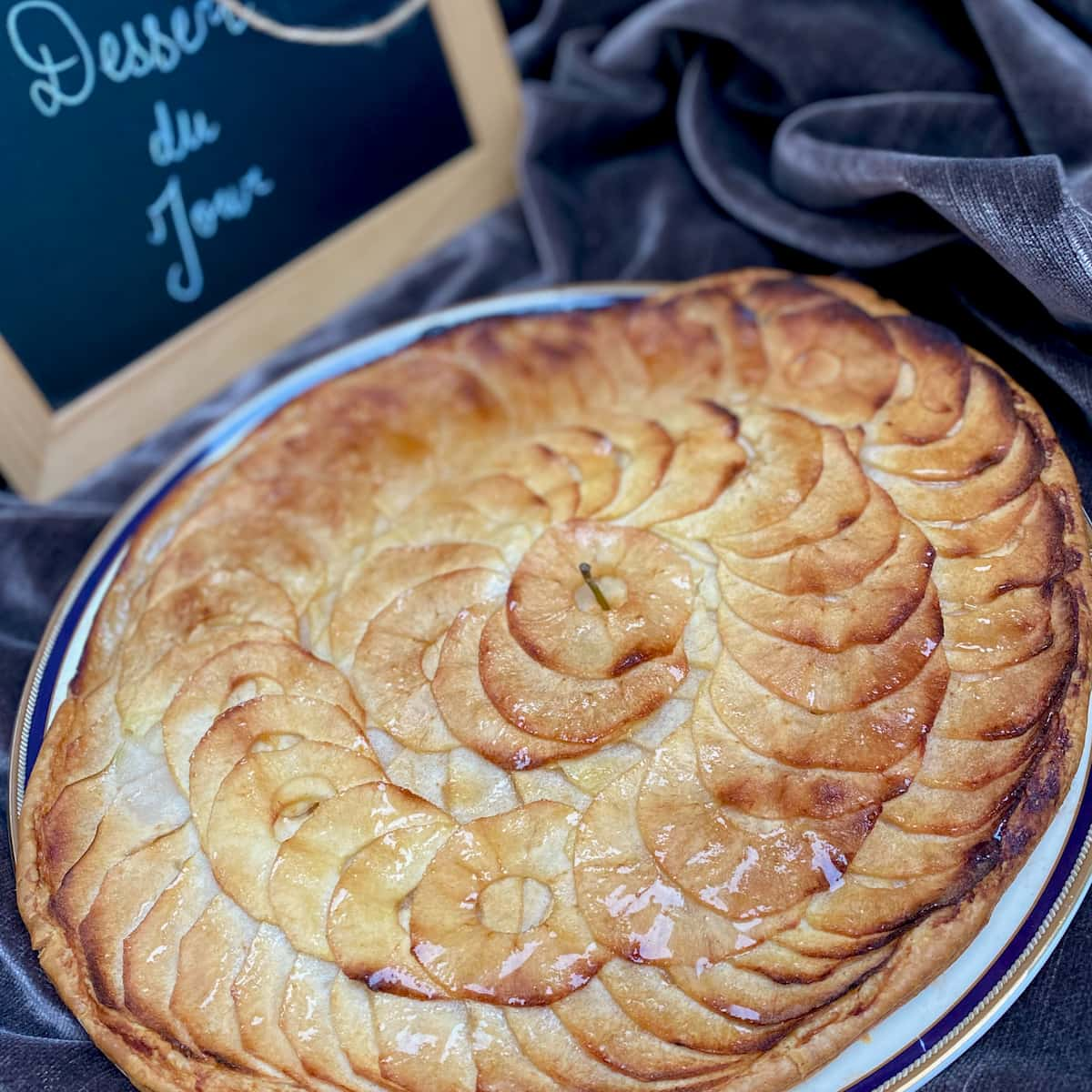 round thin tart topped with thinly sliced spiral of apples