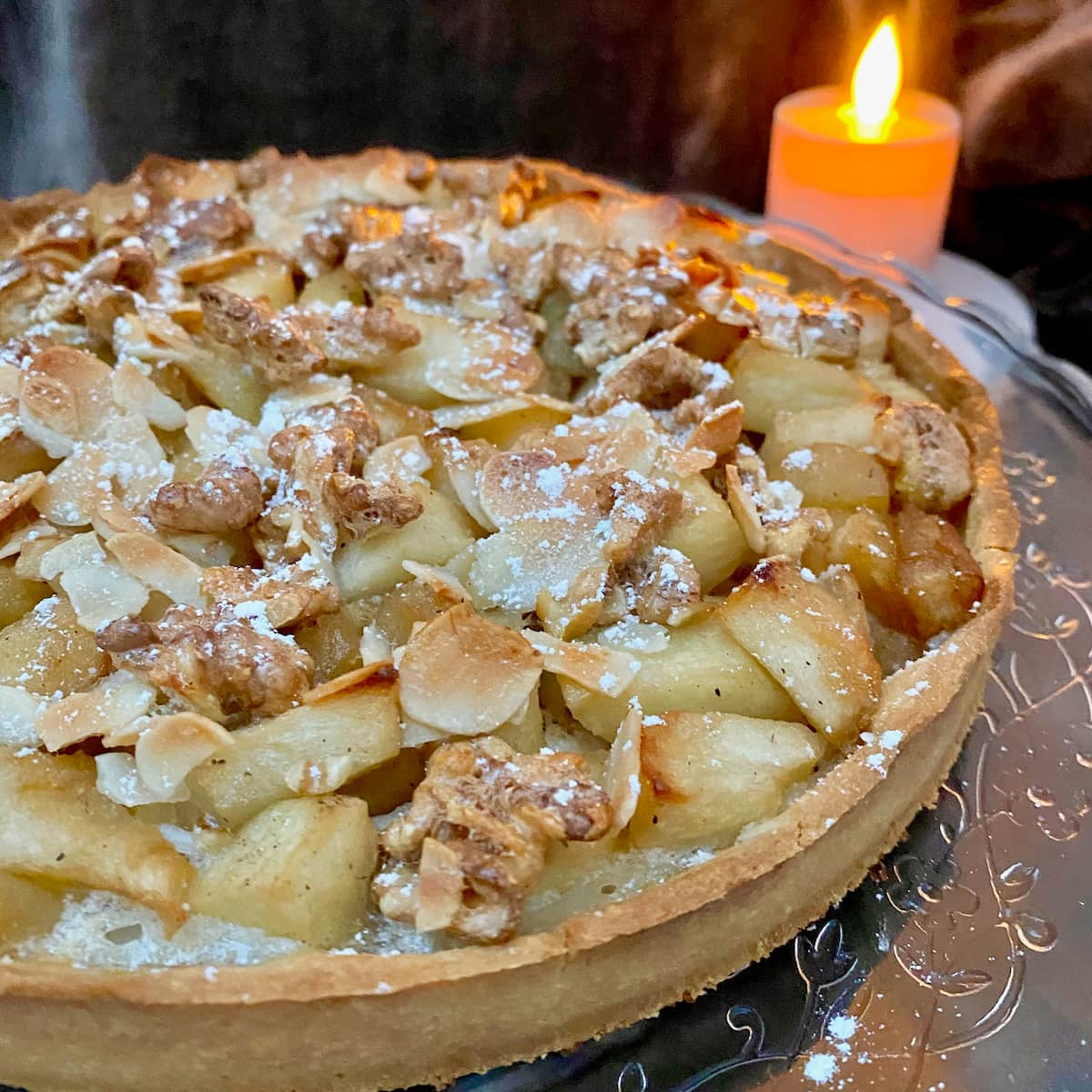 chunky baked apples in a tart topped with toasted nuts