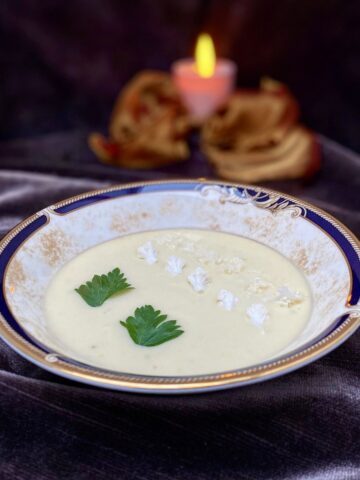 cauliflower cream soup topped with florets and parsley candlelit