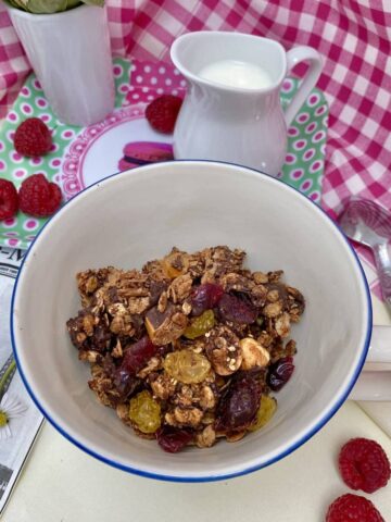 bowl of chocolate granola jug milk and raspberries