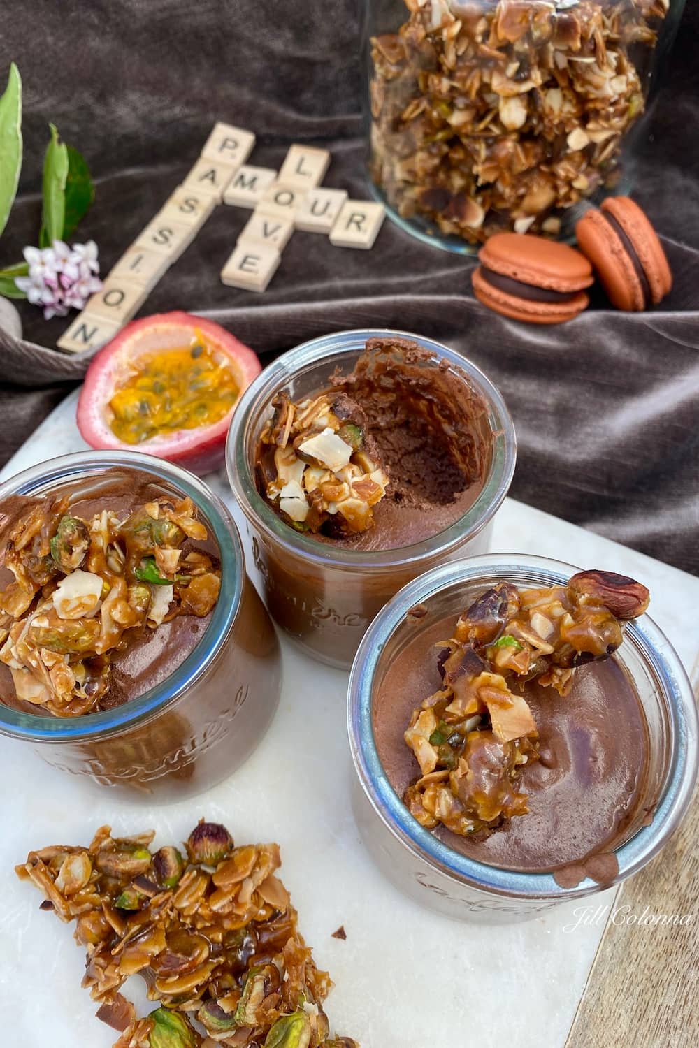 glass pots of chocolate mousse with caramel nougat, half a passionfruit