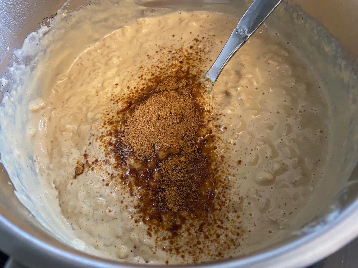 stirring rice pudding with a spoonful of brown sugar
