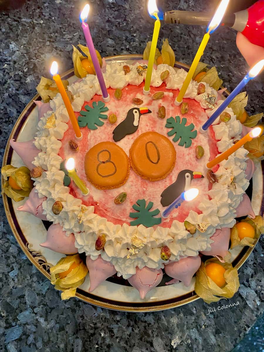 ice cream cake topped with cream, meringues and birthday candles