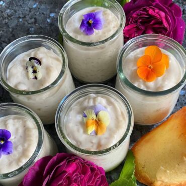glass pots of rice pudding topped with edible pansies