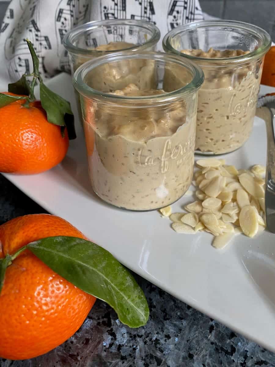 3 glass pots of slightly browned creamy rice puddings with flaked almonds