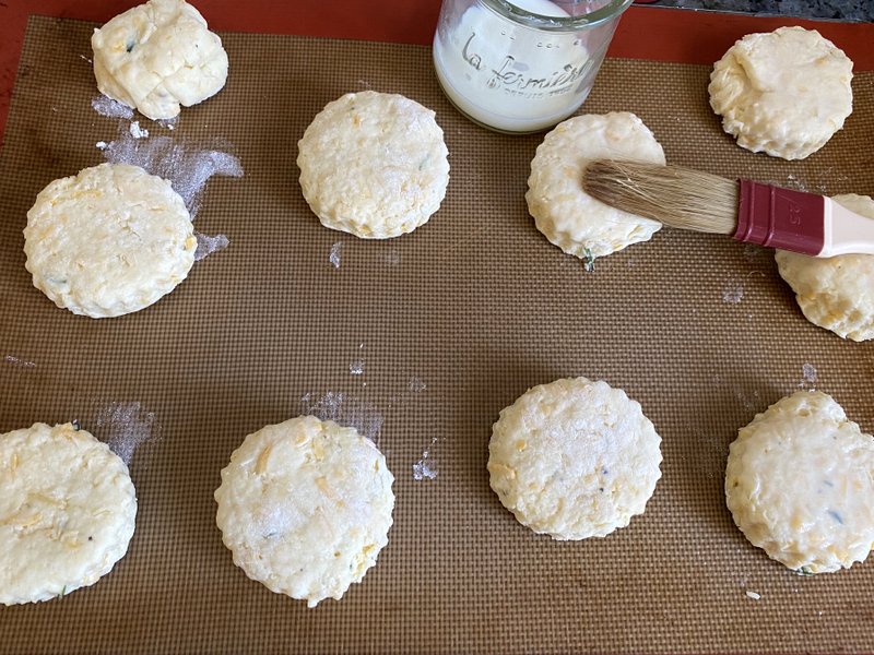 brushing on a milk glaze to scones before baking