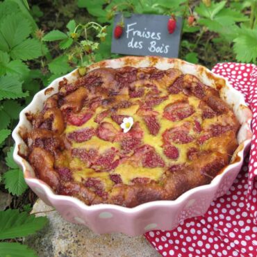 strawberry clafoutis topped with strawberry flower in the garden