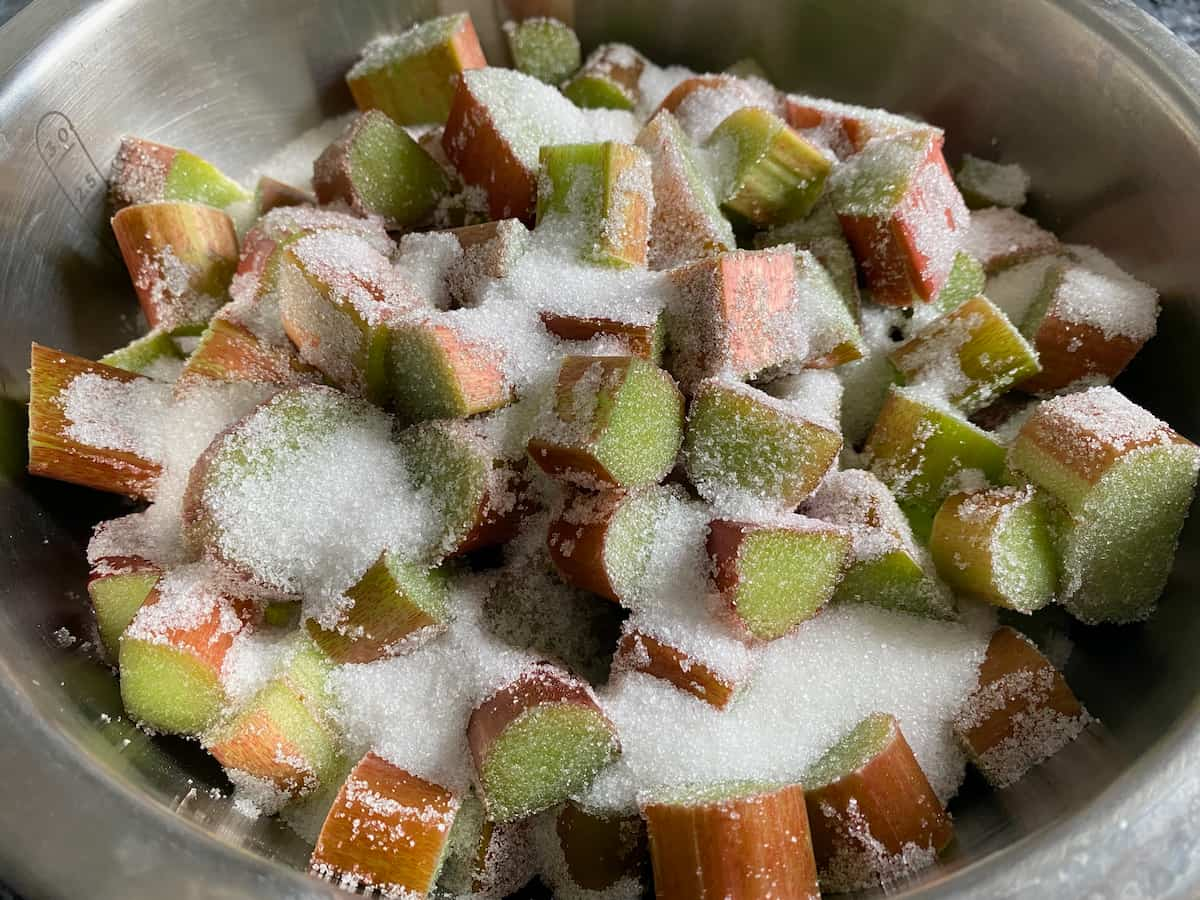 chopped rhubarb in a bowl of sugar