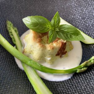 small individual asparagus clafoutis with parmesan sauce basil top