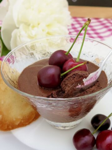 glass dish of chocolate mousse with cherries