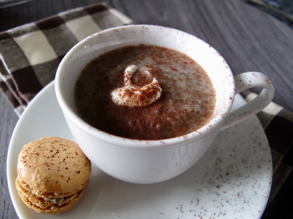 cup of soup with a mushroom savoury macaron on a saucer