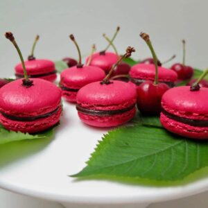 deep pink cherry chocolate macarons with stalks as decor