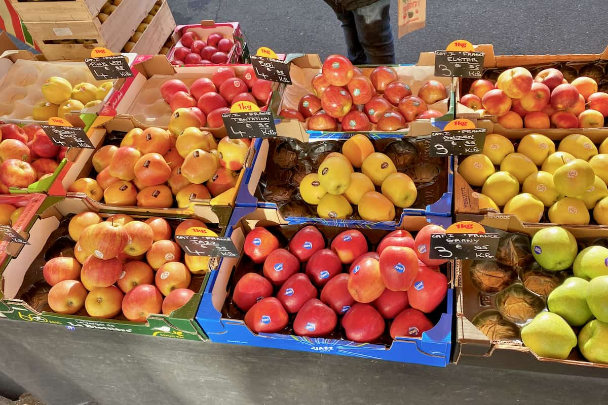 boxes of different varieties of apples at the French market