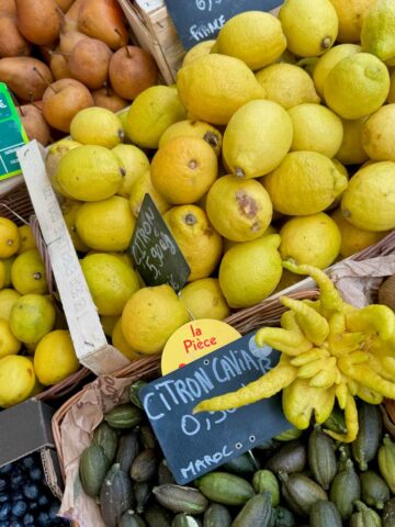 baskets of different fresh lemon varieties in a French market