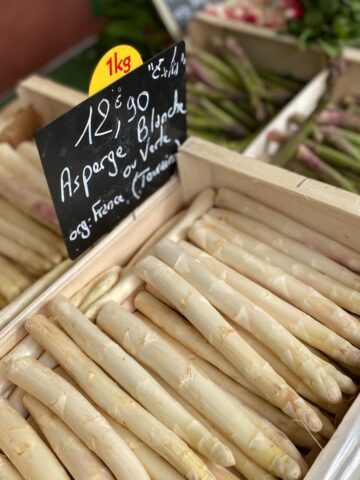 crates of green and white asparagus at the market