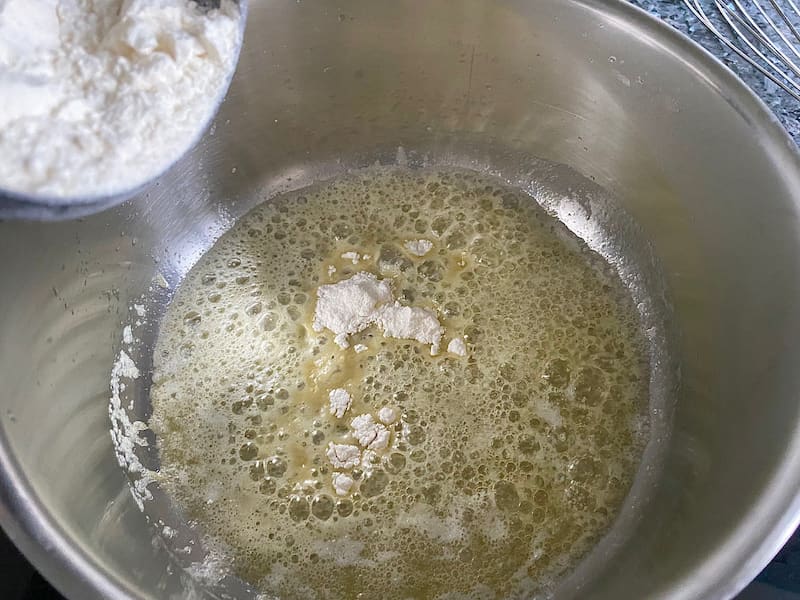 Adding flour to melted butter in a saucepan