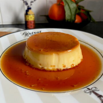 plate with eiffel tower and circle of caramel sauce around a shiny creme caramel