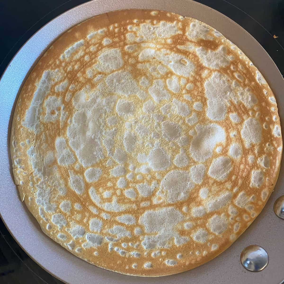 round crepe pancake perfectly cooked in a pan