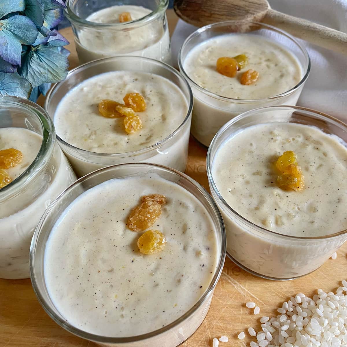 glass bowls of rice puddings topped with golden sultana raisins