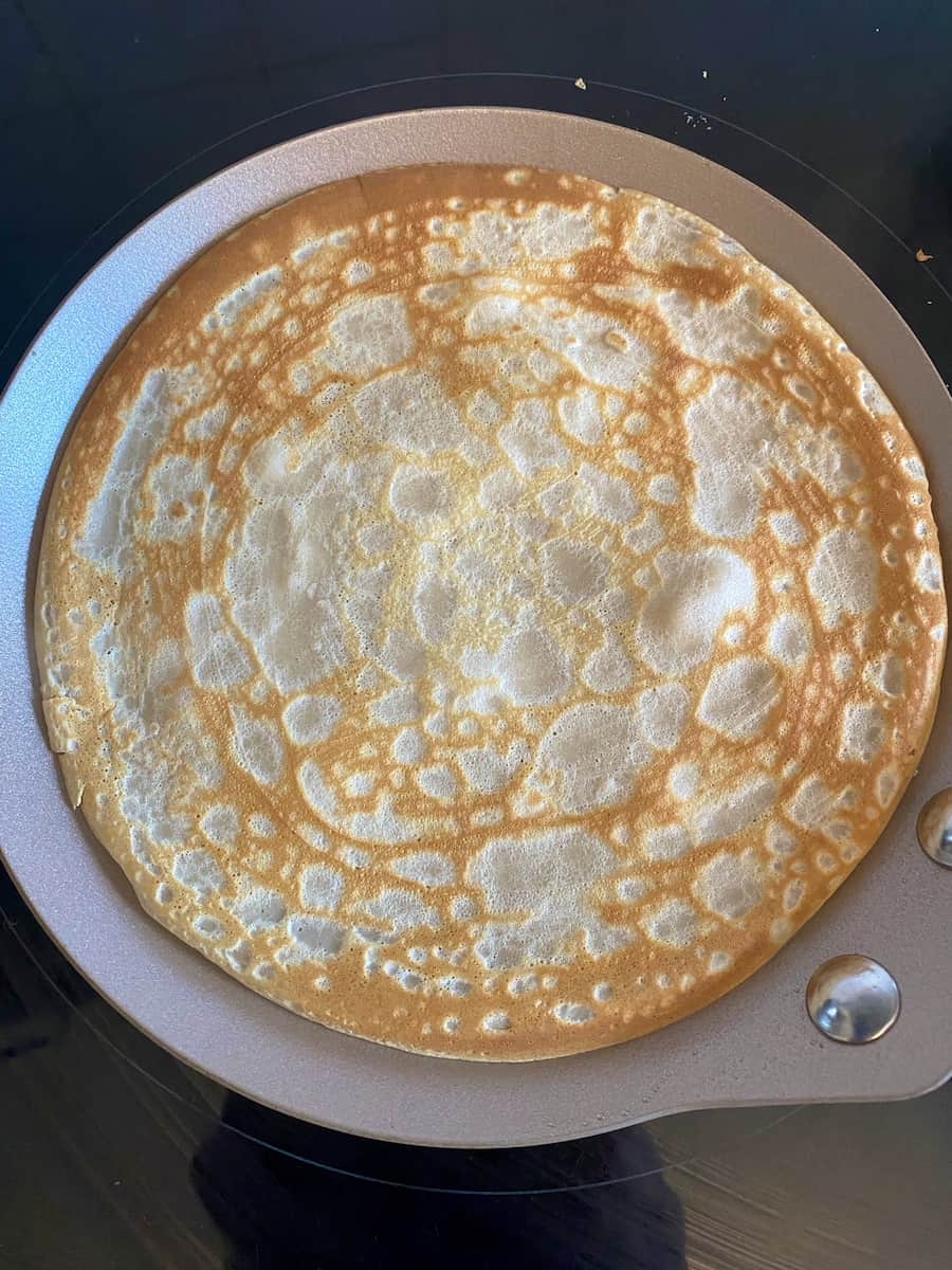 perfectly round and cooked thin pancake in a pan