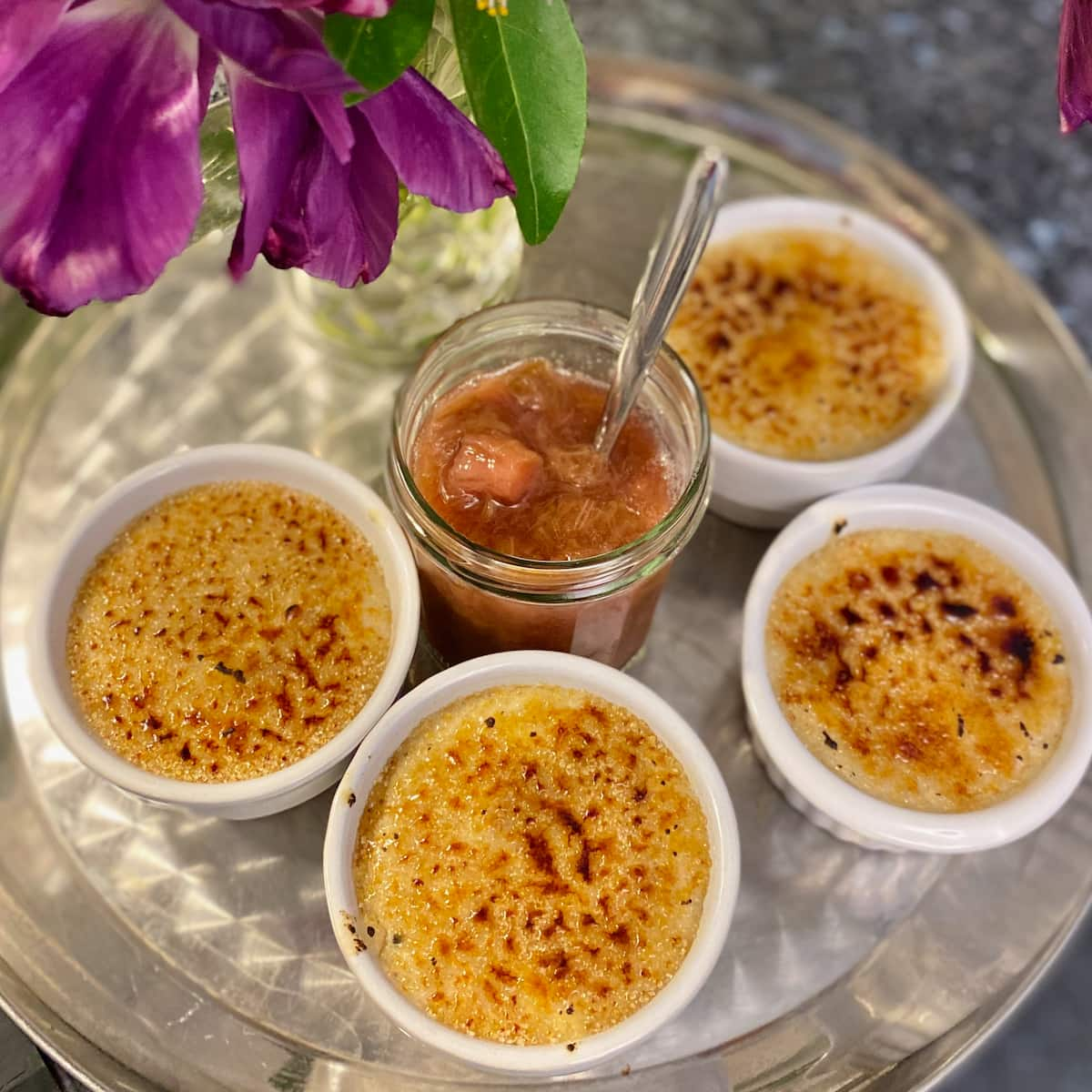 individual ramekins or rice pudding with burned caramel tops and a pot of compote