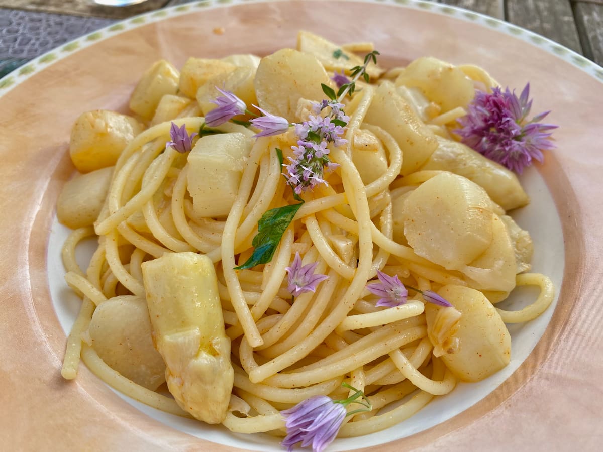 bowl of spaghetti with asparagus and herb flowers