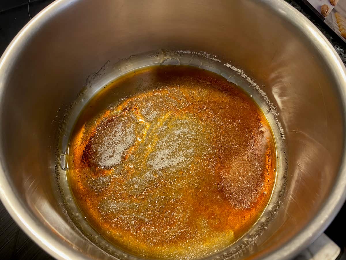 melting sugar in a saucepan over heat to dissolve the sugar and caramelise