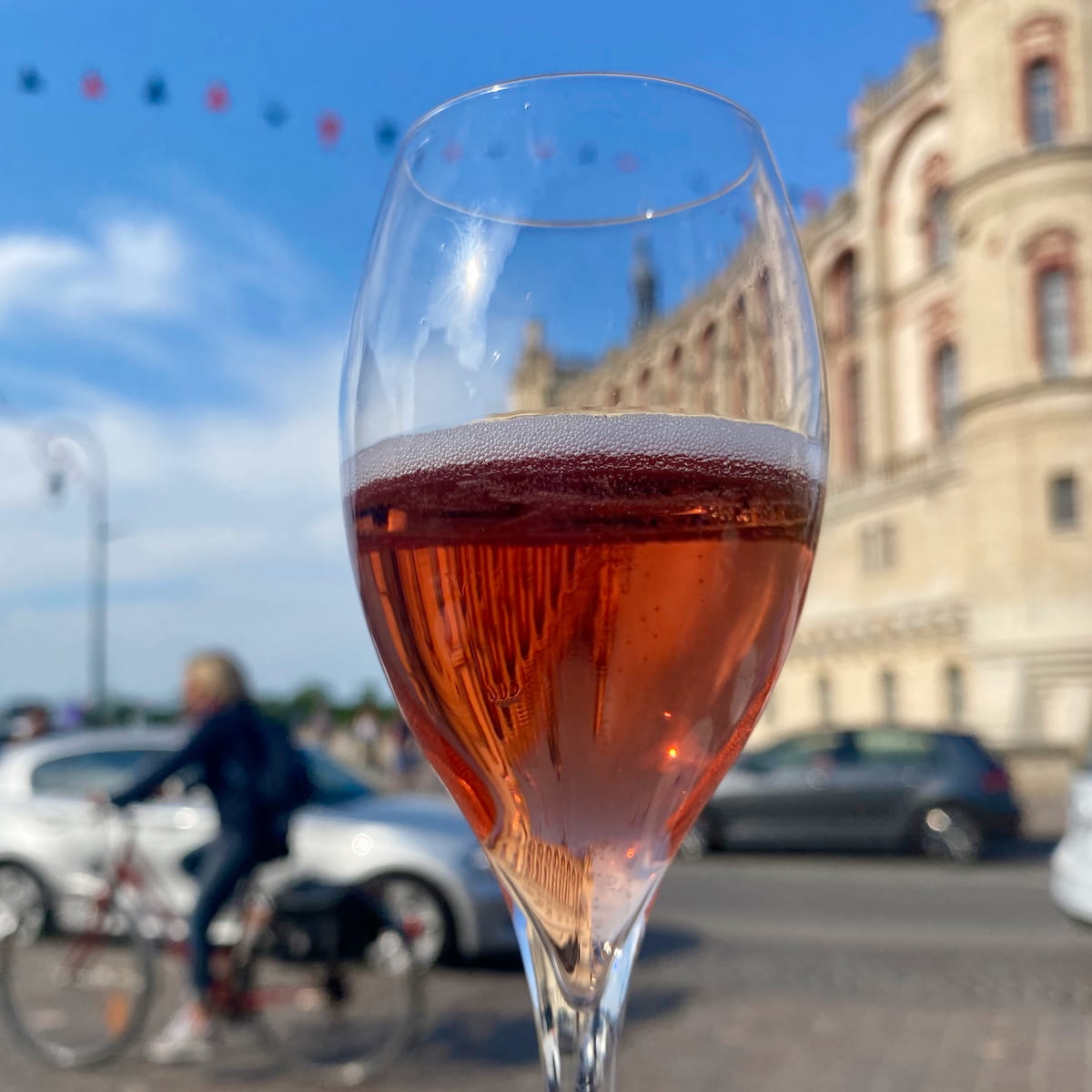 Champagne glass of French bubbly, Kir Royal in front of a castle