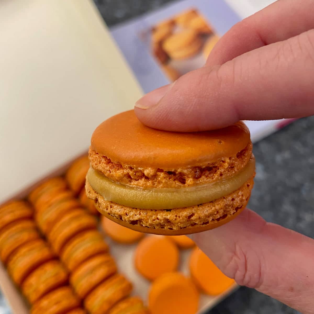 sandwiching salted caramel macaron together