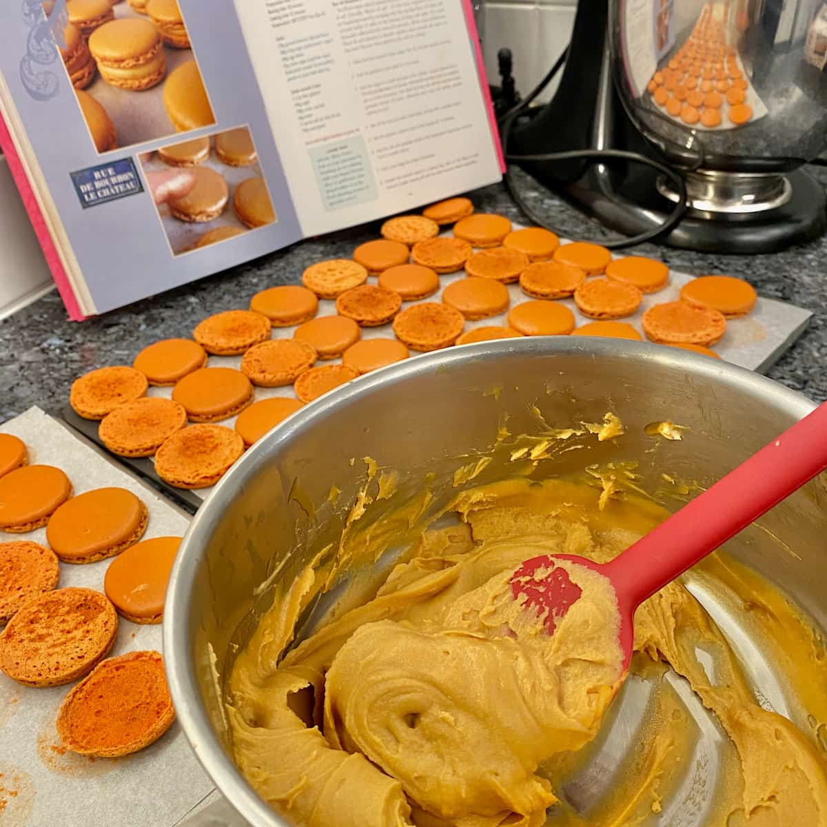 pan of salted caramel filling in front of macaron shells ready for filling