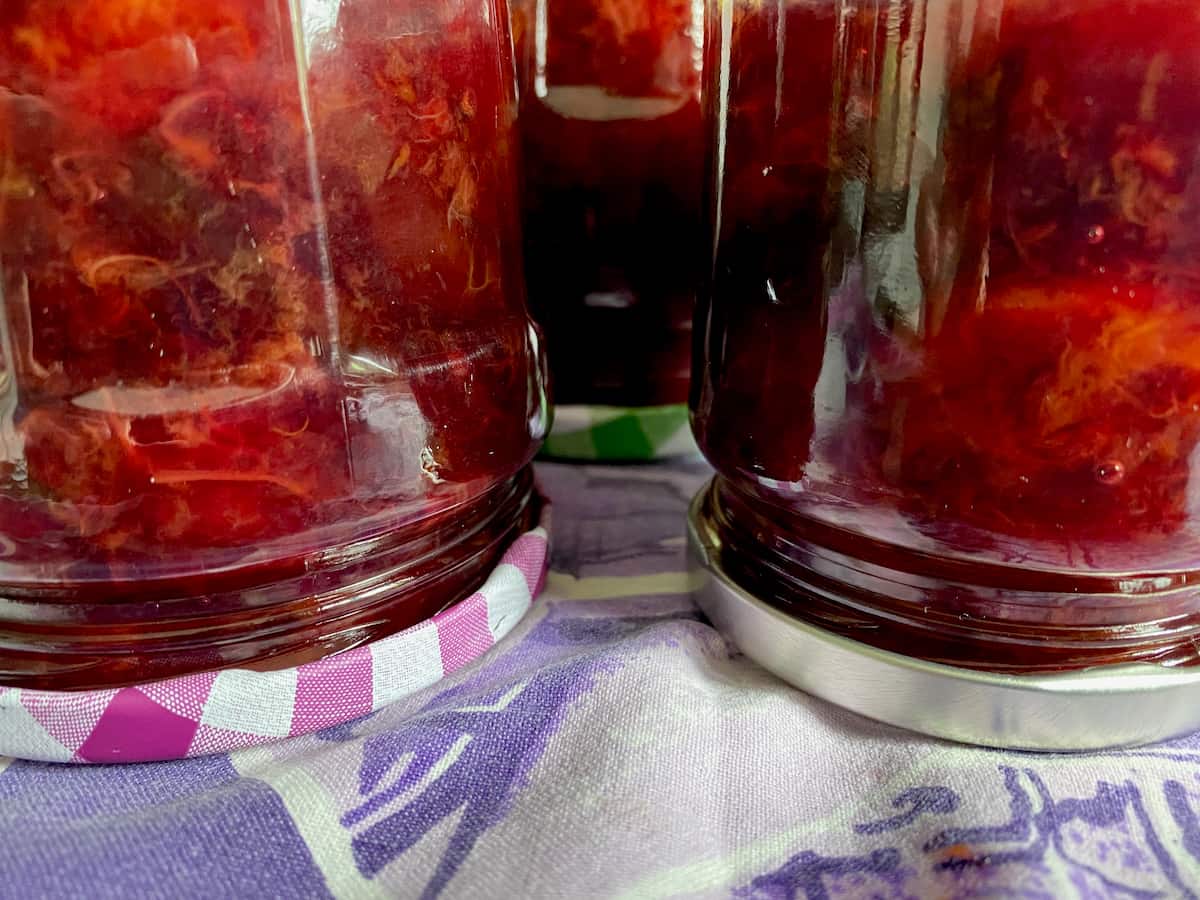 jars upturned of brightly coloured plum jam
